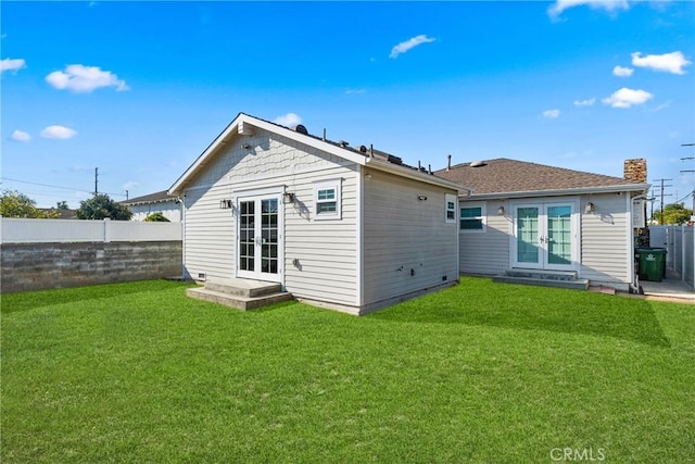 back of house featuring a yard and french doors