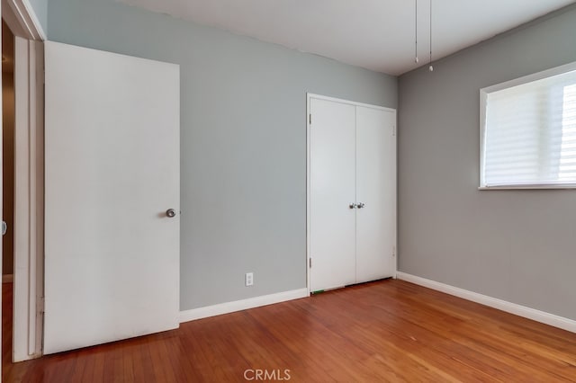 unfurnished bedroom with hardwood / wood-style flooring and a closet