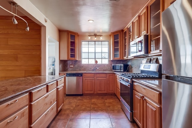 kitchen featuring tasteful backsplash, sink, stainless steel appliances, and stone countertops