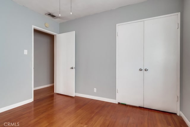 unfurnished bedroom featuring hardwood / wood-style floors and a closet