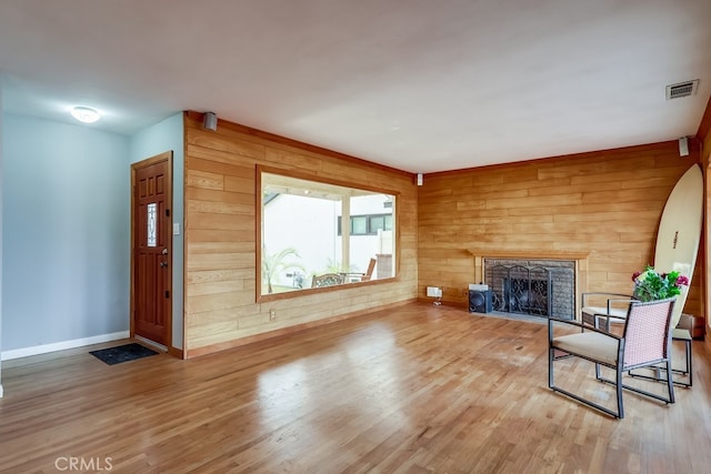 unfurnished living room with hardwood / wood-style floors and wooden walls