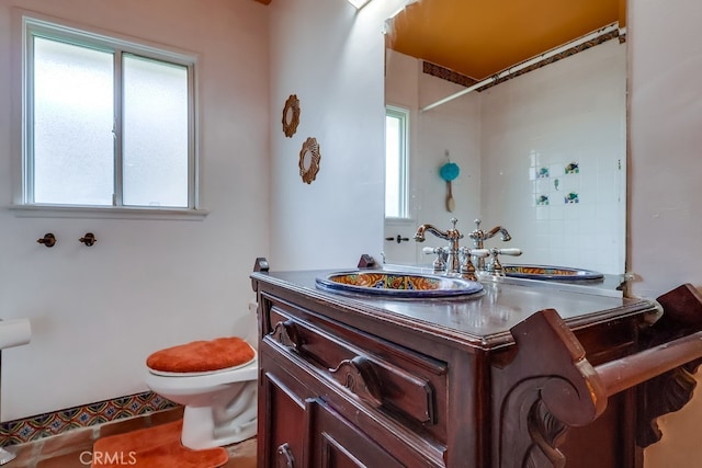 bathroom with vanity, a wealth of natural light, toilet, and walk in shower