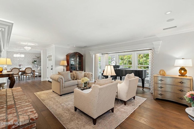 living room featuring ornamental molding, wood-type flooring, and a notable chandelier