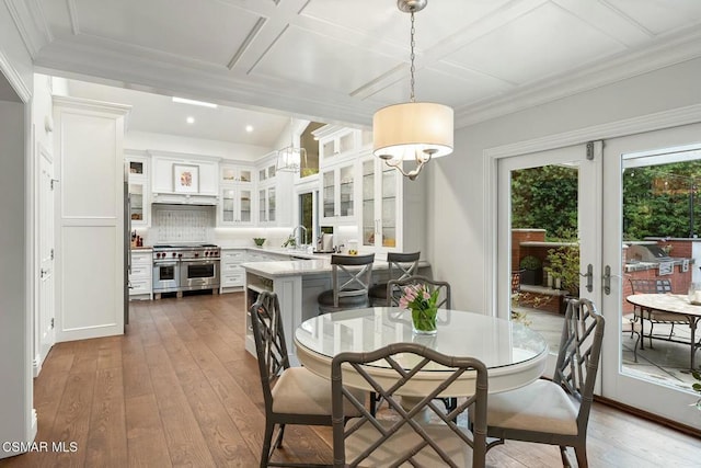 dining area with french doors, coffered ceiling, dark hardwood / wood-style flooring, and sink