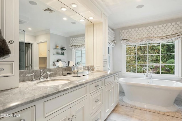 bathroom featuring ornamental molding, vanity, and a tub to relax in