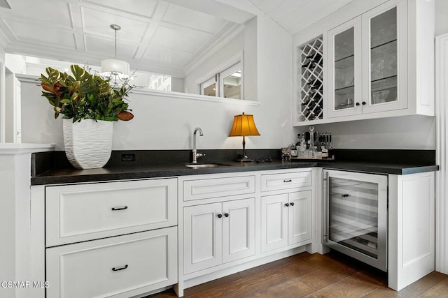 bar featuring sink, white cabinetry, dark hardwood / wood-style floors, pendant lighting, and beverage cooler