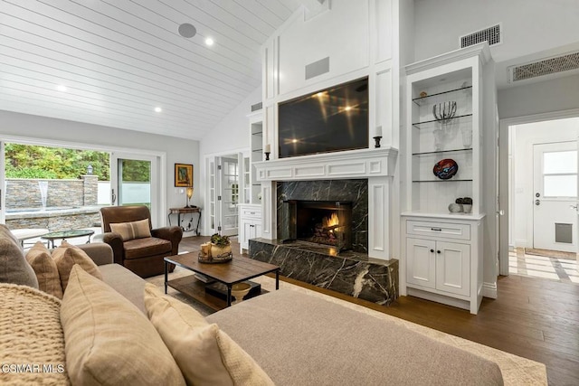 living room with a premium fireplace, dark hardwood / wood-style floors, wooden ceiling, and high vaulted ceiling