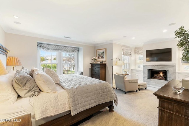 bedroom featuring ornamental molding, a fireplace, and light colored carpet