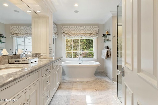 bathroom featuring crown molding, a washtub, and vanity