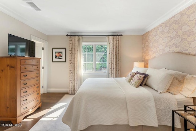 bedroom with crown molding and dark wood-type flooring