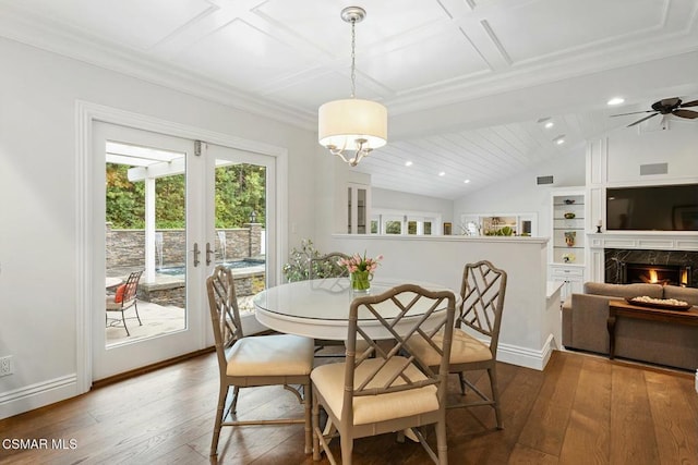 dining area featuring dark wood-type flooring, a fireplace, french doors, and vaulted ceiling with beams