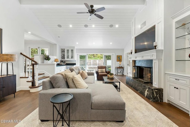 living room featuring vaulted ceiling, a fireplace, wood-type flooring, ceiling fan, and wooden ceiling