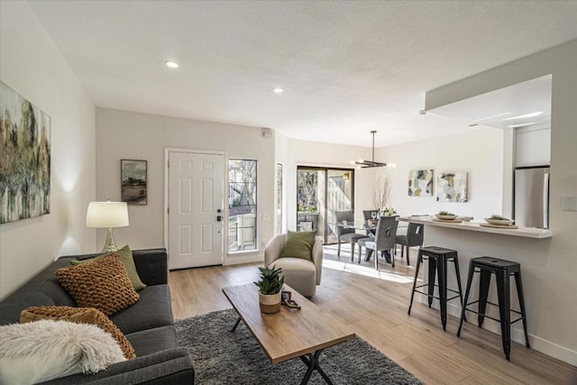 living room featuring an inviting chandelier and light wood-type flooring