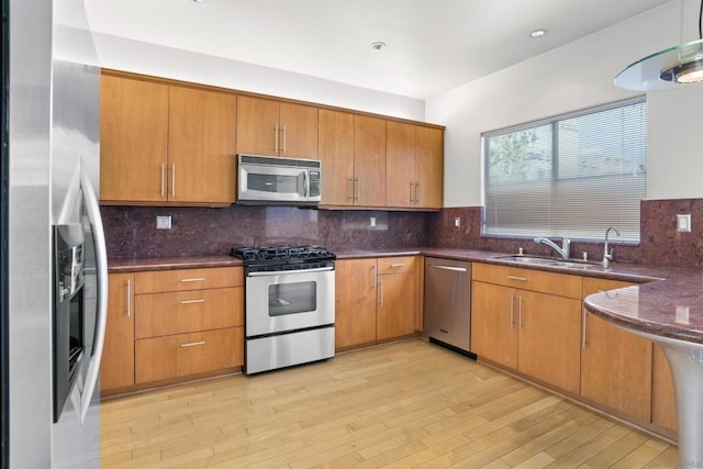 kitchen featuring tasteful backsplash, appliances with stainless steel finishes, and light wood-type flooring