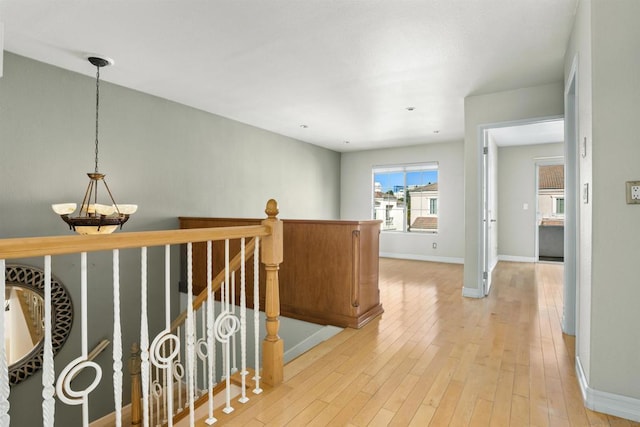 hallway featuring light hardwood / wood-style flooring and a chandelier