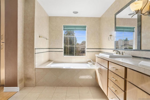 bathroom featuring tile patterned floors, tiled bath, and vanity