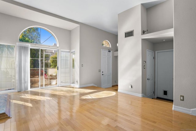 interior space with light hardwood / wood-style flooring and a high ceiling