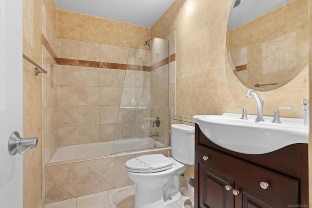 full bathroom featuring vanity, tile patterned flooring, toilet, and tiled shower / bath