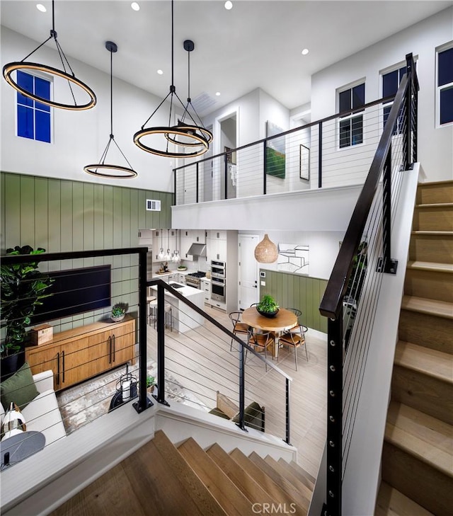 stairs with a high ceiling and wood-type flooring