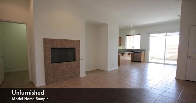 unfurnished living room featuring light tile patterned floors and a tile fireplace