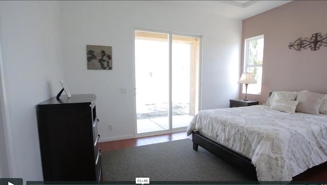 bedroom with dark hardwood / wood-style floors and access to exterior