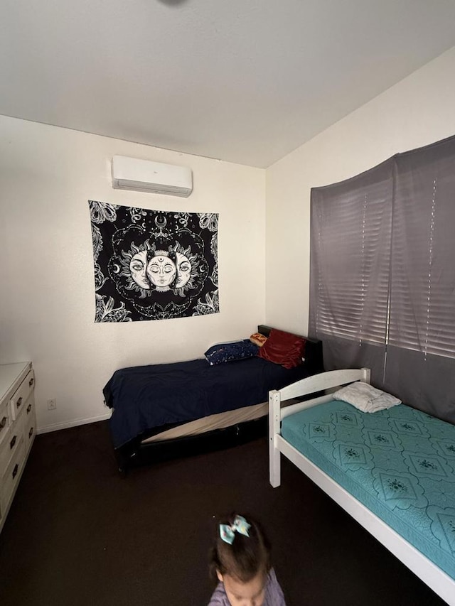 bedroom with a wall mounted air conditioner and dark carpet