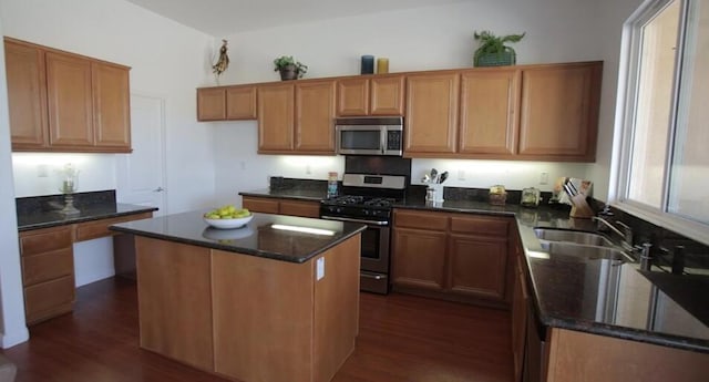 kitchen featuring sink, dark wood-type flooring, a kitchen island, and appliances with stainless steel finishes