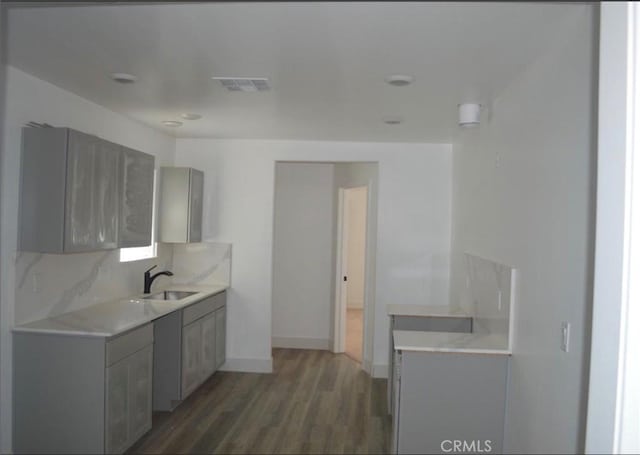 kitchen featuring dark hardwood / wood-style flooring, sink, and gray cabinets