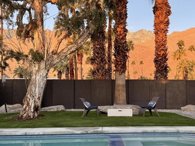 view of pool featuring a mountain view and a yard