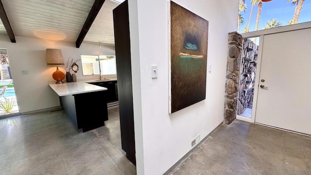 interior space with sink, concrete floors, and beam ceiling