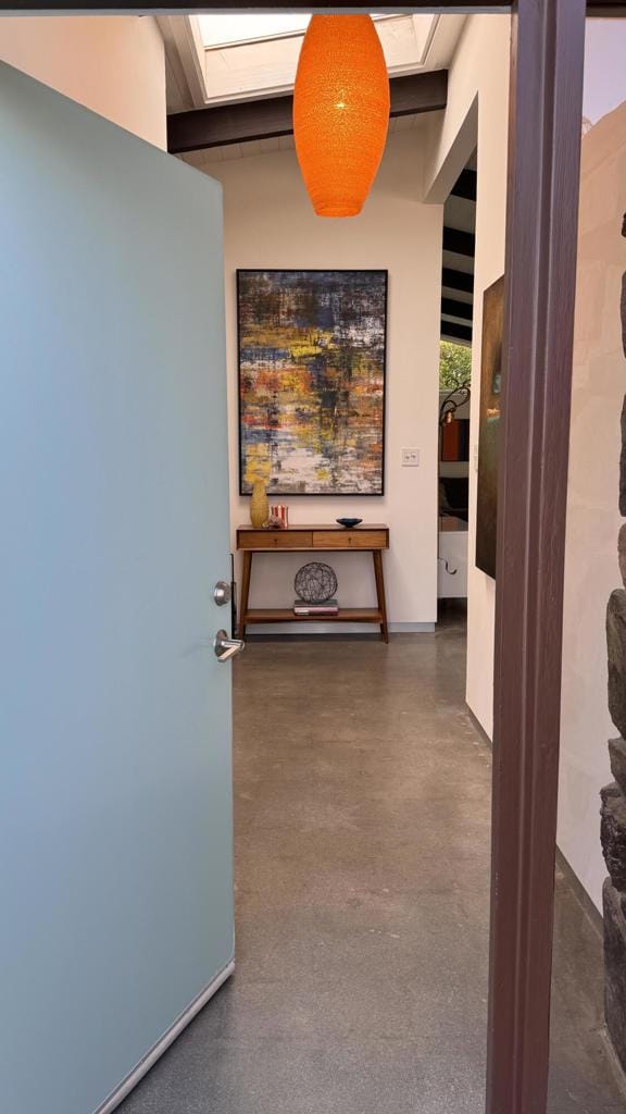 hallway featuring concrete floors and a skylight