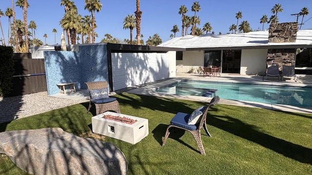 rear view of house with an outdoor fire pit, a yard, a fenced in pool, and a patio area