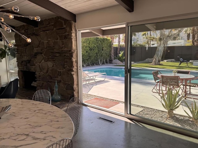 entryway featuring beamed ceiling, wood ceiling, and an outdoor stone fireplace