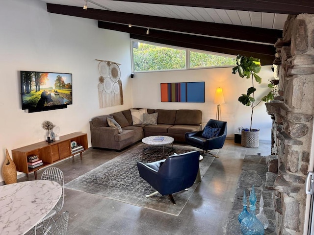 living room with rail lighting, concrete flooring, lofted ceiling with beams, a stone fireplace, and wooden ceiling