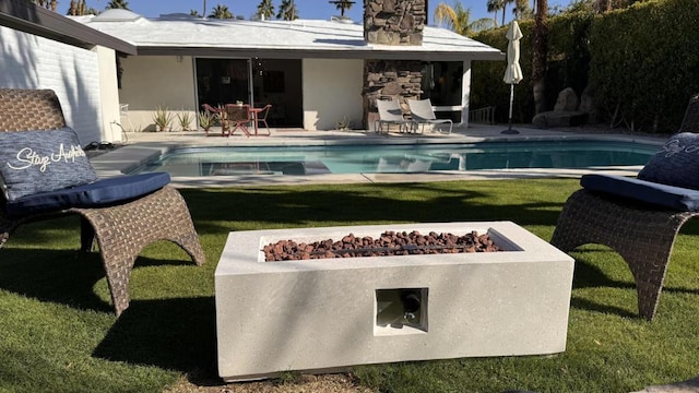 view of pool featuring a fire pit, a patio area, and a lawn