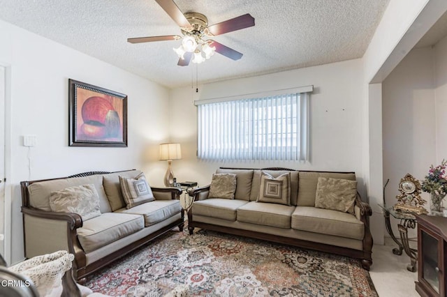 living room with ceiling fan, light colored carpet, and a textured ceiling