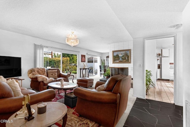 living room featuring an inviting chandelier, a fireplace, and a textured ceiling