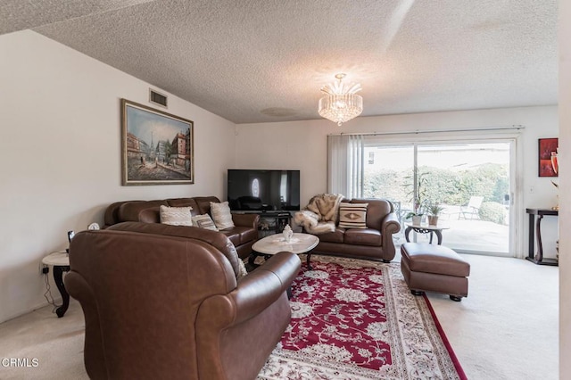 living room featuring carpet flooring, a notable chandelier, and a textured ceiling