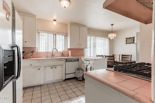 kitchen featuring pendant lighting, white cabinetry, sink, tile counters, and white appliances