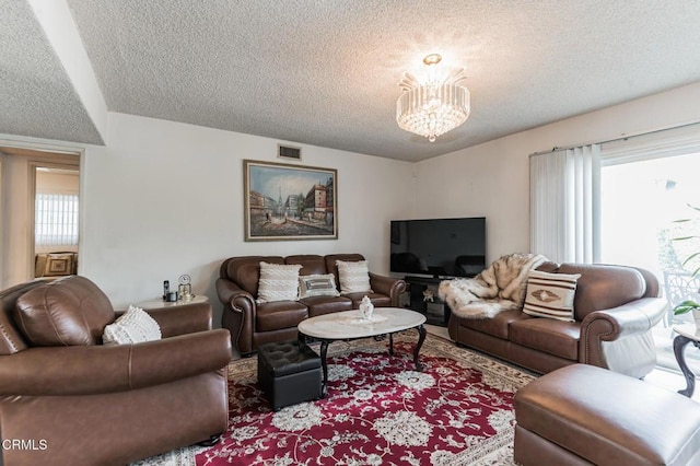 living room with a chandelier and a textured ceiling