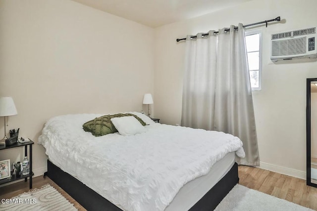 bedroom featuring wood-type flooring and a wall mounted AC