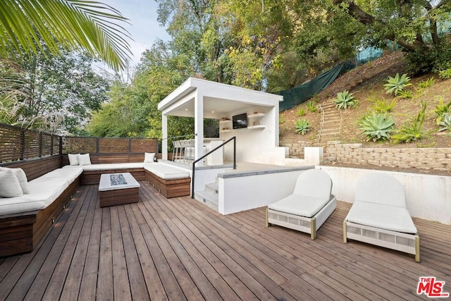 wooden deck with an outdoor living space with a fire pit