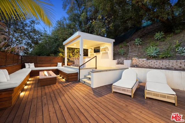 wooden terrace with an outdoor living space with a fire pit