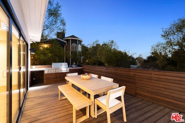 deck at dusk featuring area for grilling