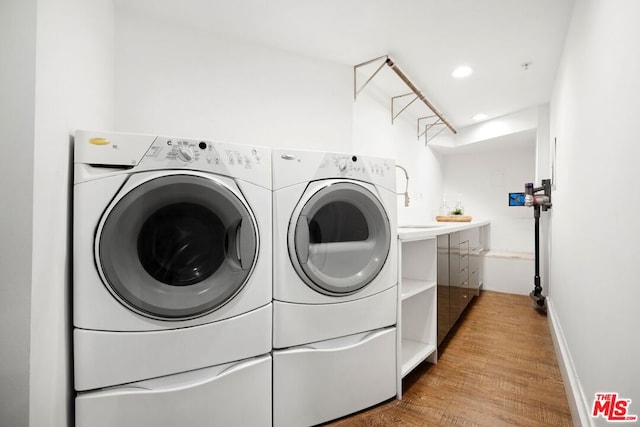 laundry room featuring independent washer and dryer and hardwood / wood-style floors