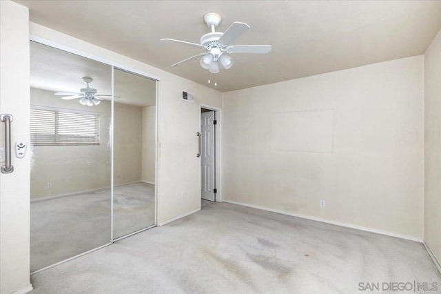 unfurnished bedroom featuring light carpet, a closet, and ceiling fan