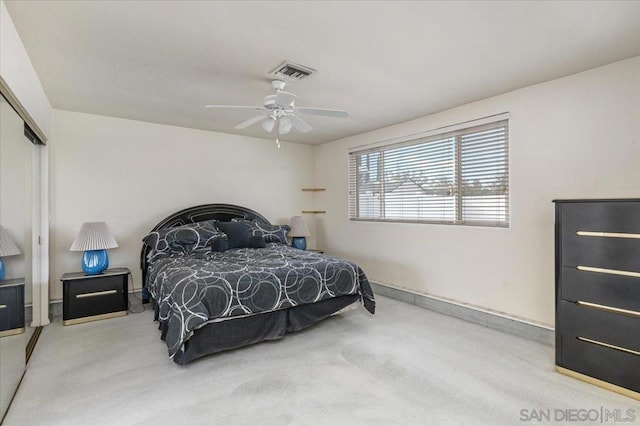 carpeted bedroom with ceiling fan and a closet