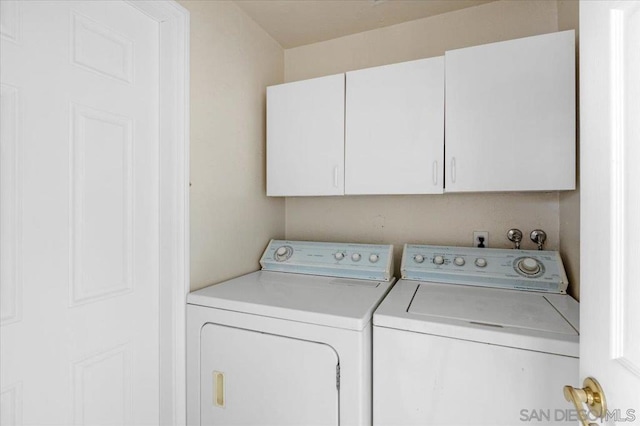 laundry room with washing machine and dryer and cabinets