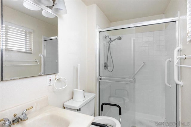 bathroom with vanity, toilet, and a shower with shower door