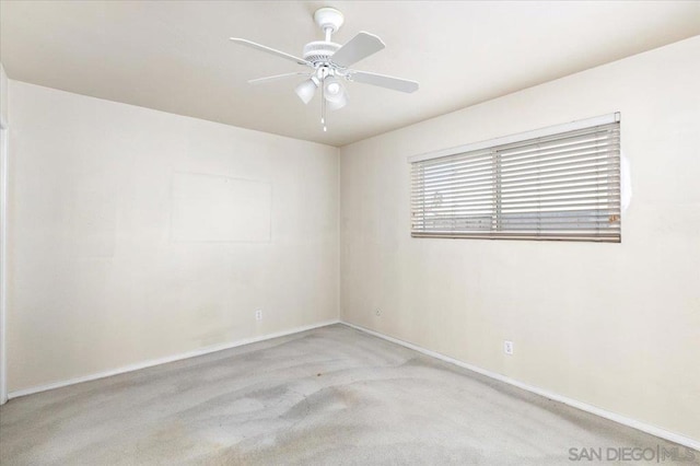 spare room featuring light colored carpet and ceiling fan